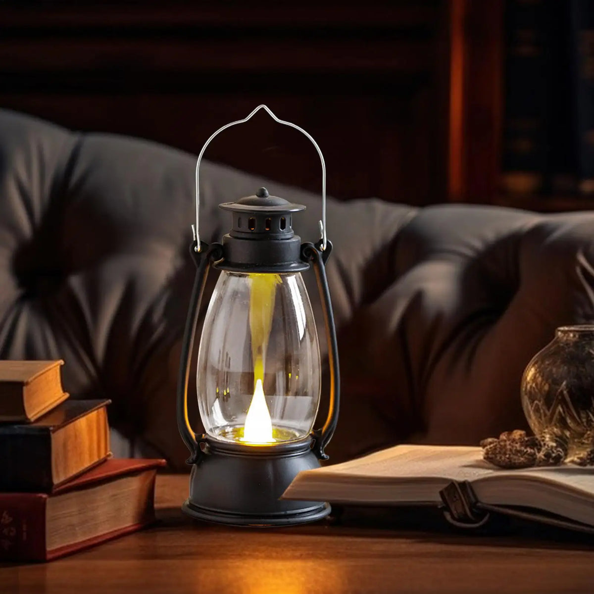 Ember Glow Lantern in black, lit on a wooden tabletop at night