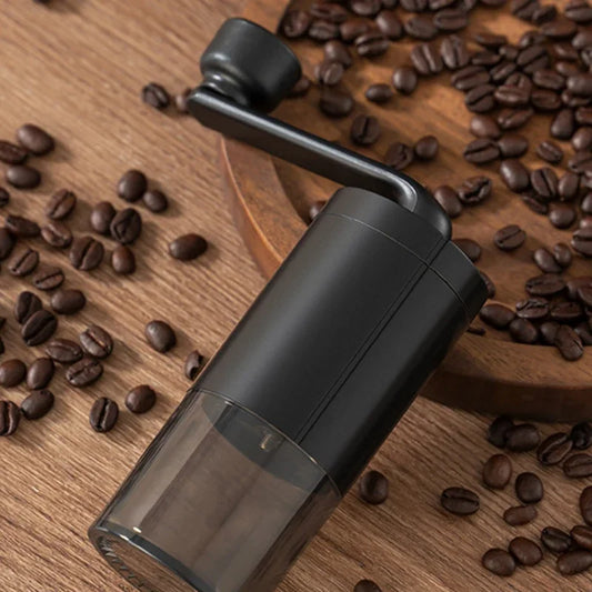 Trailgrind Manual Coffee Grinder on a wood table surrounded by whole coffee beans